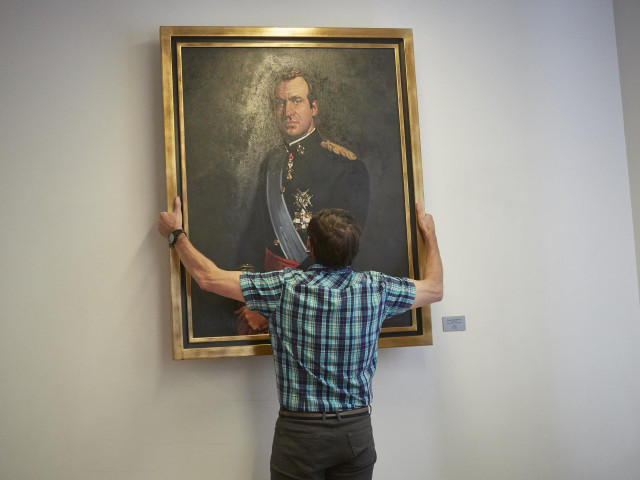 Un operario retira el retrato del rey emérito Juan Carlos I de la Sala de Gobierno del Legislativo foral del Parlamento de Navarra
