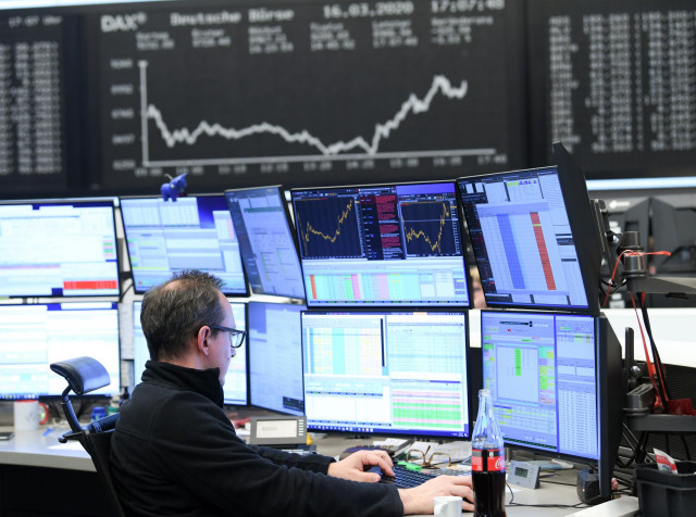 16 March 2020, Frankfurt/Main: A stock trader sits in front of his monitors in the trading room of the Frankfurt Stock Exchange. As a result of the worsening coronavirus crisis, the German share index Dax has fallen below the 9000 point mark. Photo: Arne