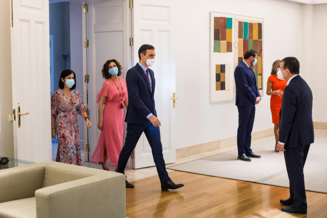 El presidente del Gobierno, Pedro Sánchez, acompañado por la ministra de Hacienda, María Jesús Montero; y la ministra de Política Territorial y Función Pública, Carolina Darias, saluda al presidente de la FEMP, Abel Caballero.
