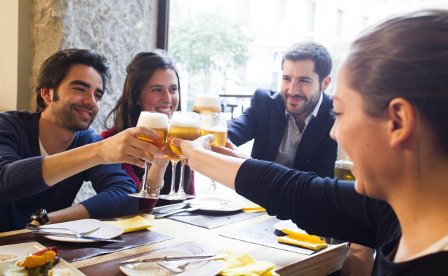 Gente brindando y bebiendo con cerveza