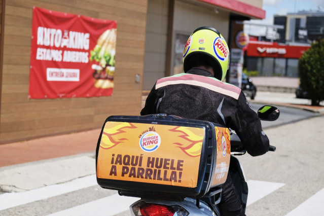 Un empleado de Burger King distribuye a domicilio desde un establecimiento de Burger King, dentro del plan Más Seguro que nunca que la cadena ha puesto en marcha en todos sus establecimientos abiertos con una serie de estrictas medidas de seguridad, que i
