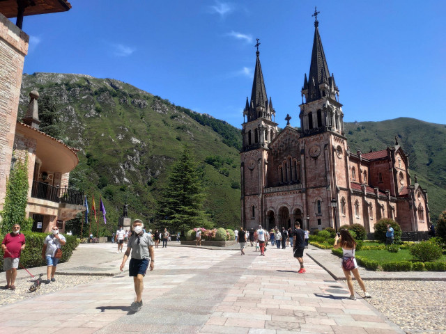Gente paseando por la recientemente acondicionada explanada del Santuario de Covadonga con mascarillas.