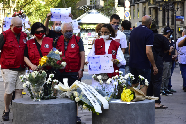 Asistentes dejan rosas blancas y carteles en recuerdo a las 16 personas fallecidas el 17 de agosto de 2017