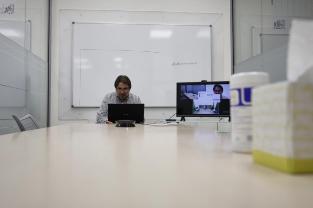 Un profesor da una clase de forma telemática en una academia
