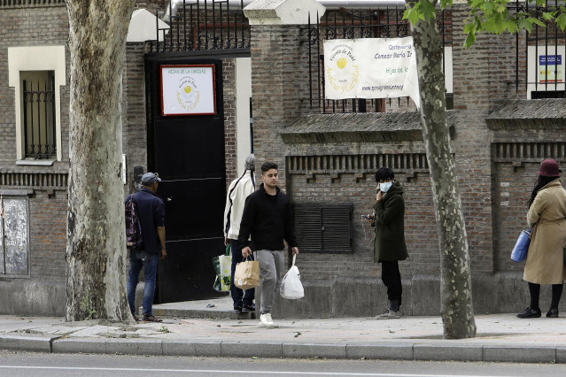 Decenas de personas esperan en la cola a las puertas del Comedor Social María Inmaculada deMadrid