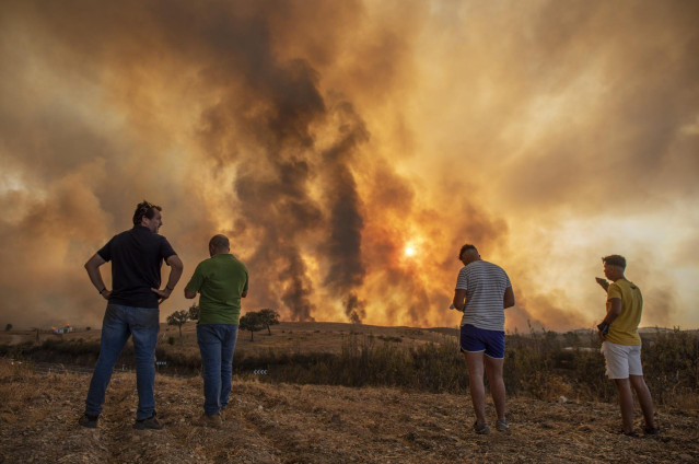 Vecinos contemplan el incendio de Almonaster