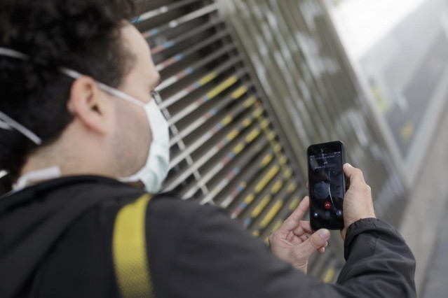 Un hombre protegido con mascarilla realiza una videollamada por su teléfono móvil en Madrid en abril de 2020
