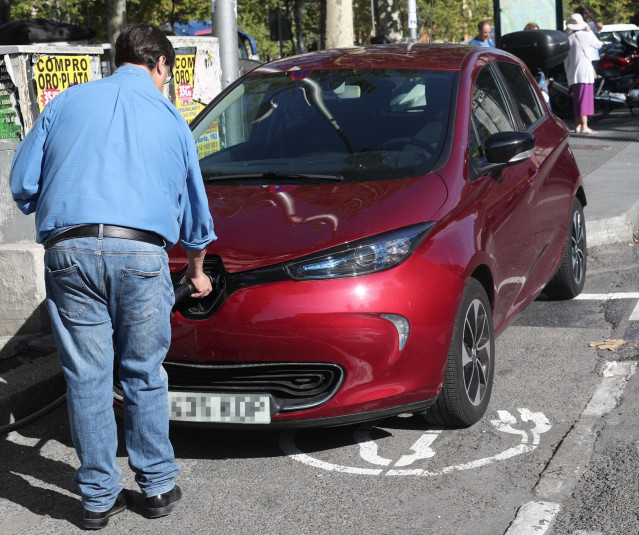 Un hombre carga su coche en un punto de carga para coches eléctricos en Madrid.