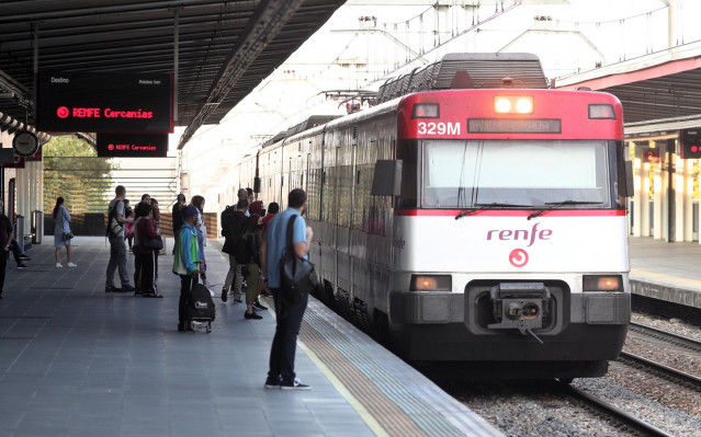 Varios pasajeros se disponen a coger un tren en el andén de la estación de tren de Renfe de Alcorcón (Madrid)