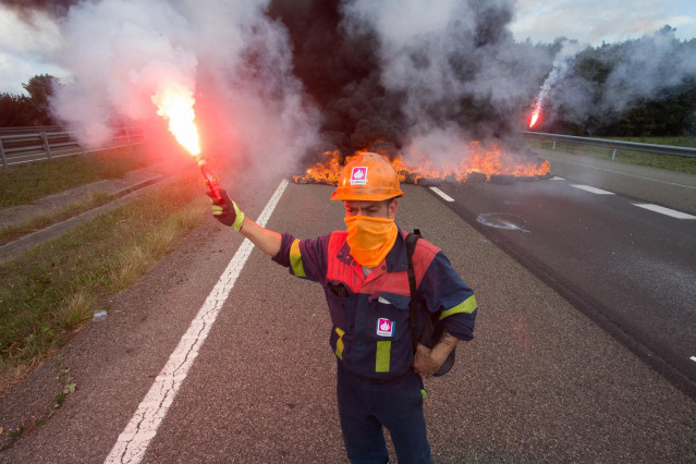 Un trabajador de Alcoa San Cibrao enciende una bengala durante una manifestación en la que han cortado la Autopista A6 con la quema de neumáticos, en Outeiro de Rei, Lugo, Galicia (España), a 22 de septiembre de 2020.