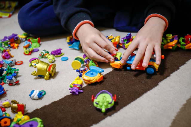 Un niño juega en su casa con unos muñecos