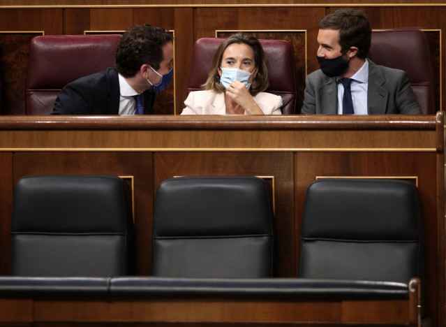 (I-D) Los diputados del PP Teodoro García Egea, Cuca Gamarra y Pablo Casado charlan en sus escaños durante una sesión plenaria en el Congreso