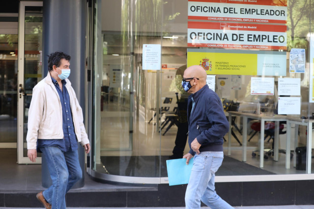 Un hombre con mascarilla pasa por una oficina de empleo de Madrid (España)