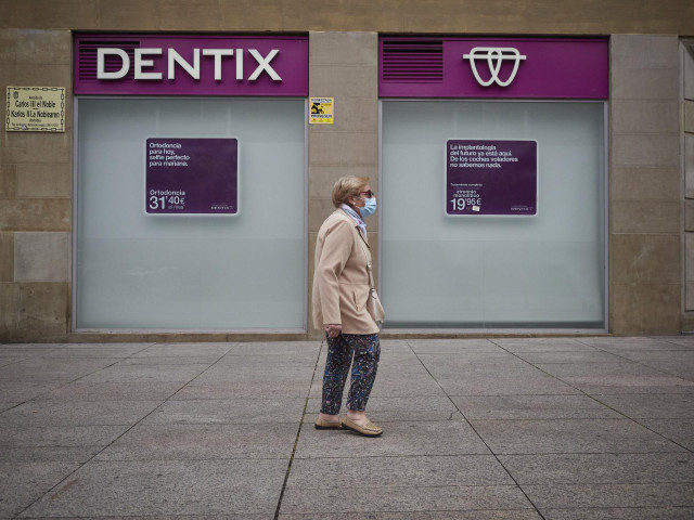 Una mujer paseas enfrente de una clínica. En Pamplona, Navarra (España), a 25 de mayo de 2020.