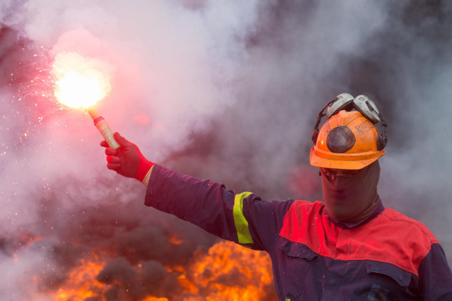 Un trabajador de Alcoa San Cibrao enciende una bengala durante una manifestación en la que han cortado la Autopista A6 con la quema de neumáticos, en Outeiro de Rei, Lugo, Galicia (España), a 22 de septiembre de 2020. Con la concentración, los trabajadore