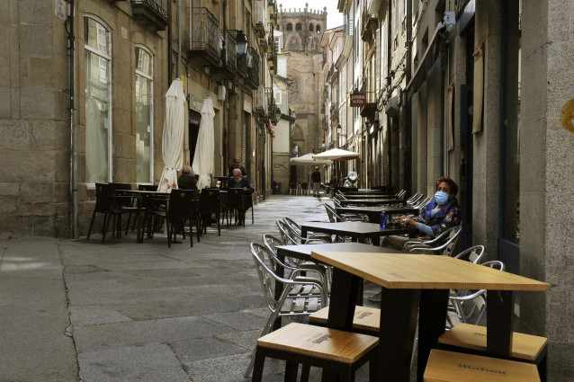 Una mujer permanece sentada en una terraza del barrio de O Couto el mismo día en el que han prohibido las reuniones entre no convivientes ante el aumento de contagios de Covid-19. En Ourense, Galicia, (España), a 3 de octubre. Esta medida, impuesta por Sa