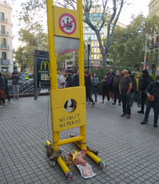 Los CDR colocan una guillotina de cartón con una foto del rey Felipe VI y una cabeza de cerdo en la plaza Urquinaona de Barcelona este sábado.