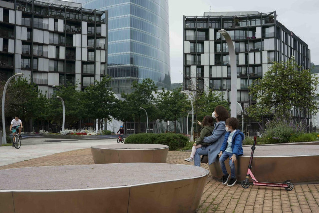 Una mujer sentada con una niña y un niño en el primer día en el que los menores de 14 años pueden salir a la calle, en Bilbao (País Vasco/España) a 26 de abril de 2020.