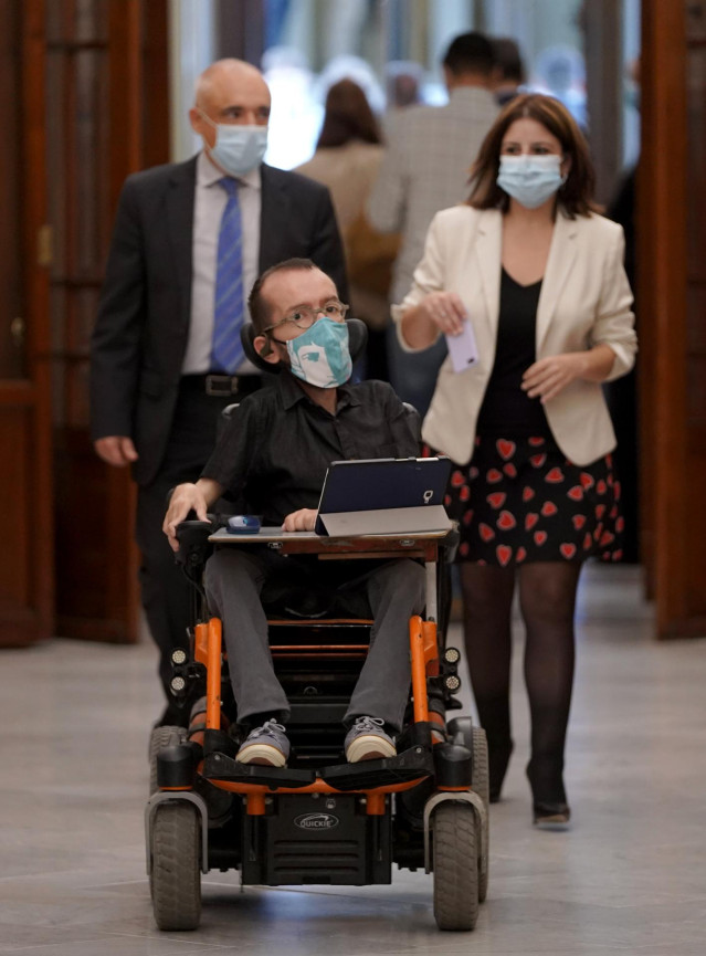 El portavoz parlamentario de Unidas Podemos, Pablo Echenique, llega una sesión de control al Gobierno en el Congreso de los Diputados. Detrás, los socialistas Adriana Lastra y Rafael Simancas