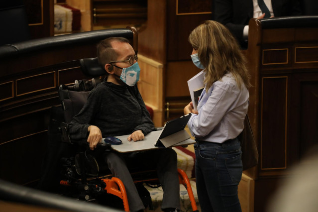 El portavoz de Unidas Podemos en el Congreso, Pablo Echenique, mantiene una conversación con la ministra de Trabajo y Economía Social, Yolanda Díaz, durante una sesión plenaria en el Congreso