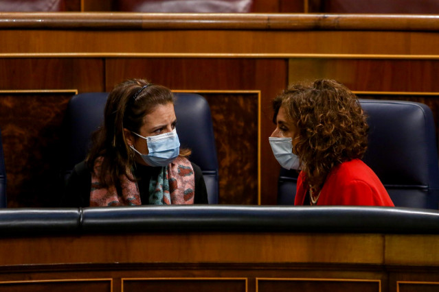 La ministra Portavoz y de Hacienda, María Jesús Montero (d), mantiene una conversación con la portavoz del PSOE en el Congreso, Adriana Lastra, durante una sesión plenaria en el Congreso