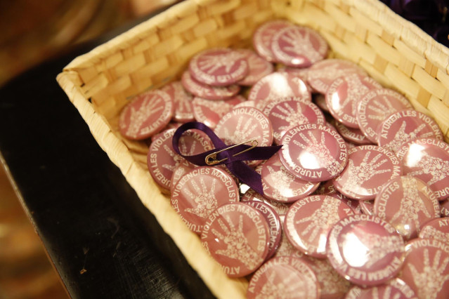 Un lazo morado y pines contra la violencia machista, en un acto en el Parlament.