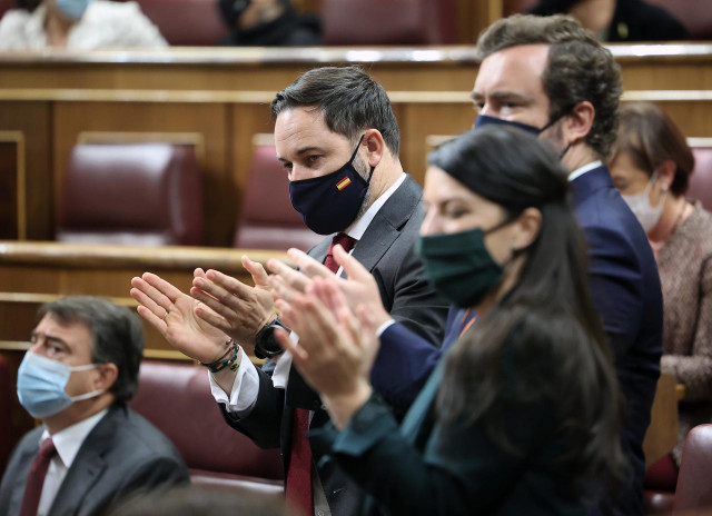 (I-D) El presidente de Vox, Santiago Abascal; el portavoz de Vox en el Congreso de los Diputados, Iván Espinosa de los Monteros; y la portavoz de Vox en el Congreso de los Diputados, Macarena Olona, aplauden durante el pleno en el que se debate la moción