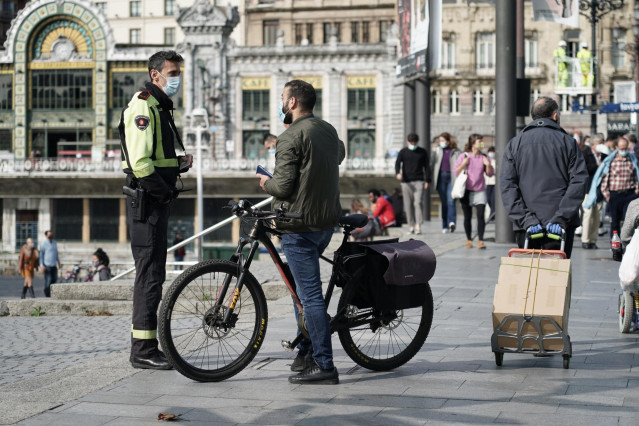 Un hombre habla con un agente un día después de la petición del Gobierno vasco de la declaración del estado de alarma debido al aumento de casos de Covid-19, en Bilbao, Vizcaya, País Vasco, (España), a 24 de octubre de 2020.