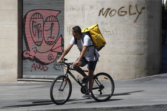 Un 'rider' de Glovo, circula en su bicicleta por una calle de Madrid.