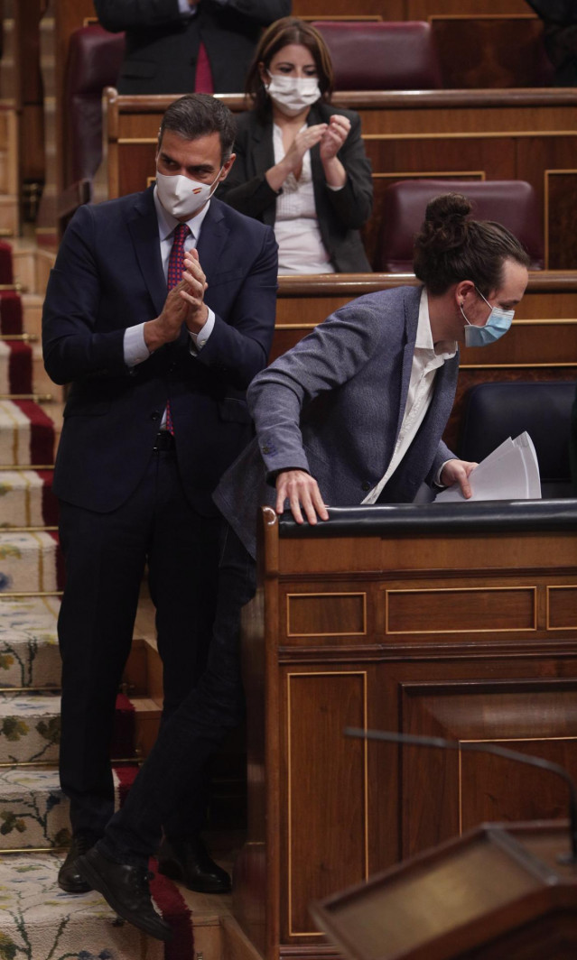 El presidente del Gobierno, Pedro Sánchez, aplaude al vicepresidente segundo del Gobierno, Pablo Iglesias, tras su intervención en la segunda sesión del pleno en el que se debate la moción de censura planteada por Vox, en el Congreso de los Diputados, Mad