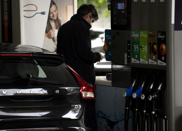 Un hombre echa gasolina a su coche en una gasolinera.