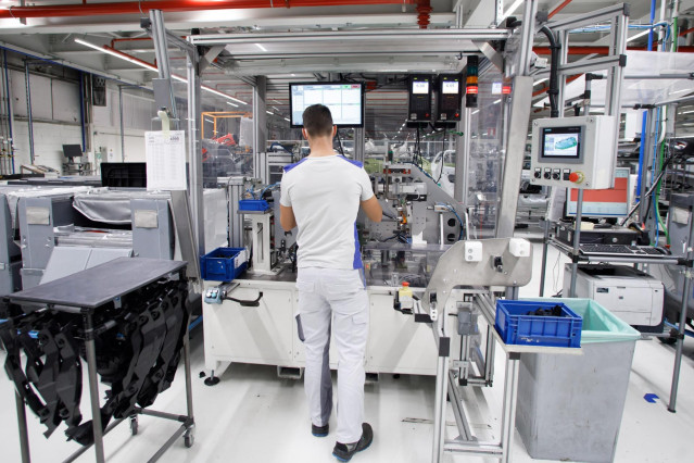 Un trabajador en la máquina de preparación de faros de Montaje.