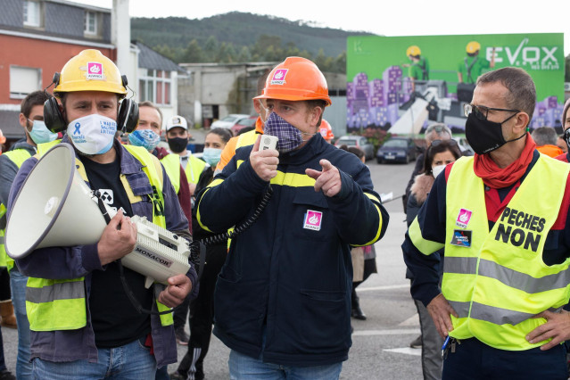 El presidente del comité de empresa de la planta de Alcoa en San Cibrao, José Antonio Zan (c), habla a través de un megáfono durante una nueva manifestación convocada por el Comité de Alcoa en la que cortan el tráfico en la carretera N-642 y el acceso al