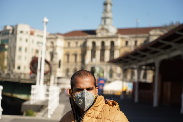 Un hombre pasea protegido con mascarilla por Bilbao tras el anterior anuncio de Estado de Alarma en España por el avance de coronavirus