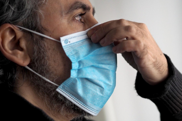 Un hombre se coloca una mascarilla para evitar el contagio de Covid-19