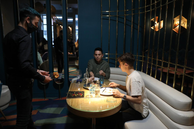 Un camarero sirve a dos comensales de una mesa del Restaurante Marta, Cariño!, en Madrid (España), a 16 de octubre de 2020.
