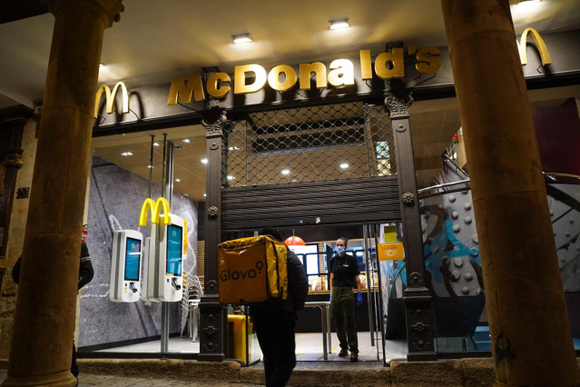 Un trabajador de Glovo entra en un McDonald's en Salamanca la noche en la que la ciudad ha vivido su primer toque de queda dictado por la Junta de Castilla y León para toda la región