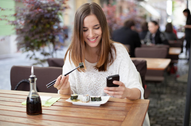 Joven comiendo sola en un restaurante