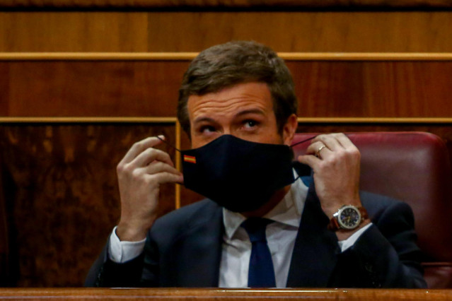 El líder del PP, Pablo Casado, se coloca la mascarilla durante una sesión plenaria