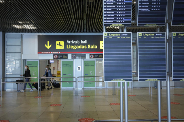 Personas abandonan una de las salidas de la sala de llegadas de la Terminal 1 del Aeropuerto de Barajas.