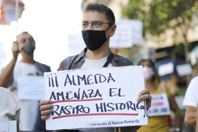 El cofundador de Podemos y director del Instituto 25 de Mayo del partido morado, Juan Carlos Monedero, sostiene una pancarta donde se puede leer 