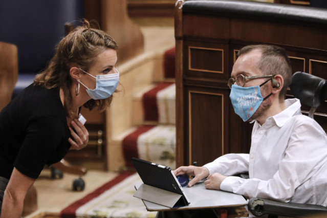 La diputada de la CUP, Mireia Vehí, habla con el portavoz de Unidas Podemos en el Congreso de los Diputados, Pablo Echenique, durante una sesión plenaria