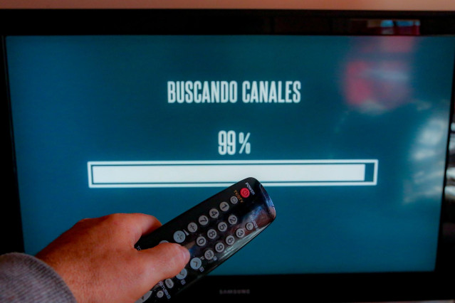 Una persona utiliza su mando de la televisión para buscar canales