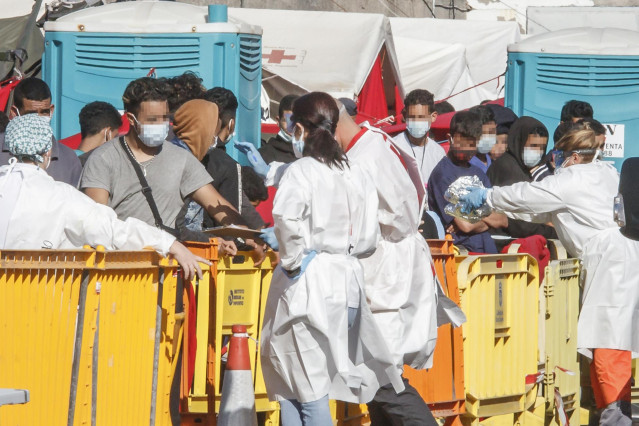 Varios inmigrantes son atendidos por personal sanitario en el Muelle de Arguineguín, en Gran Canaria