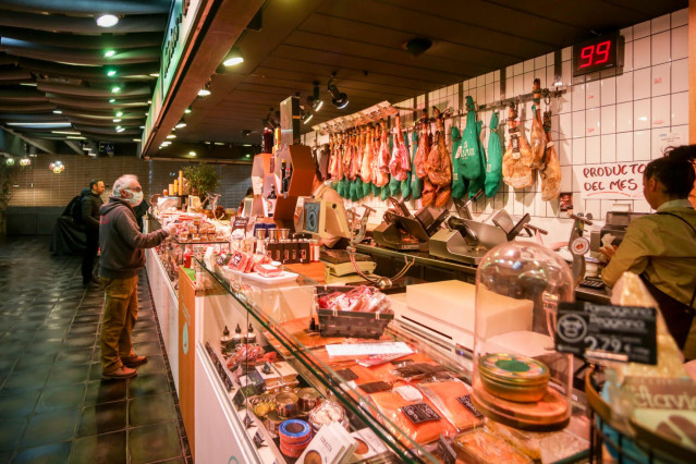 Varios clientes hacen la compra en un puesto de carne y embutidos (Archivo)