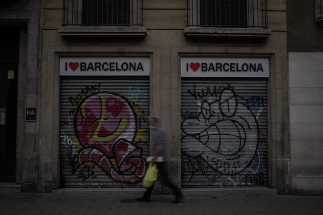 Un hombre camina al lado de dos tiendas turísticas en Barcelona, Catalunya (España), a 16 de noviembre de 2020. El turismo internacional se desplomó este verano debido como consecuencia del coronavirus. Además, el pasado 15 de octubre el Govern de la Gene