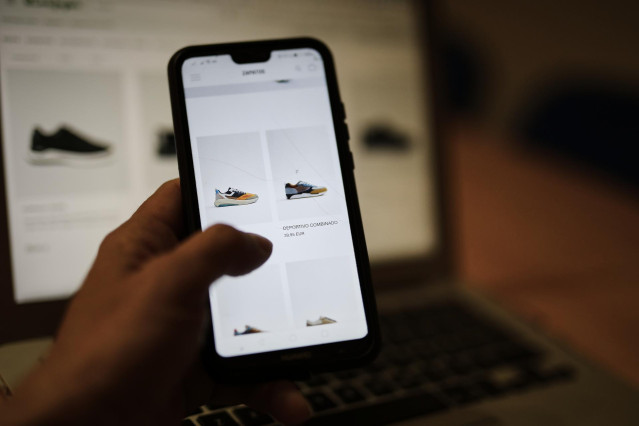 Una persona observa en su móvil artículos de moda en la página de un comercio online de moda, en Madrid (España), a 28 de octubre de 2020.