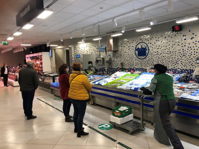 Gente comprando frescos en el supermercado