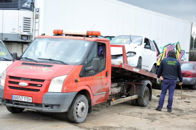 Un coche es retirado por la empresa de descontaminación y desguace de vehículos.