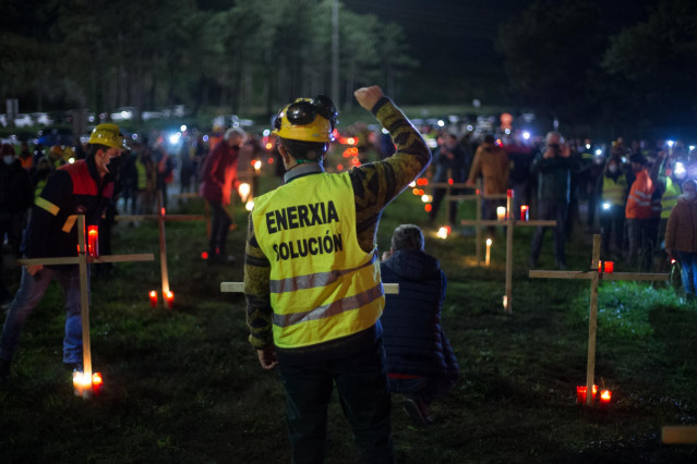 Un trabajador levanta el brazo como signo de protesta durante un velatorio nocturno simbólico convocado por la fábrica de Alcoa, en  en San Cibrao, A Mariña, Lugo, Galicia (España), a 28 de noviembre de 2020. La concentración se produce como signo de prot